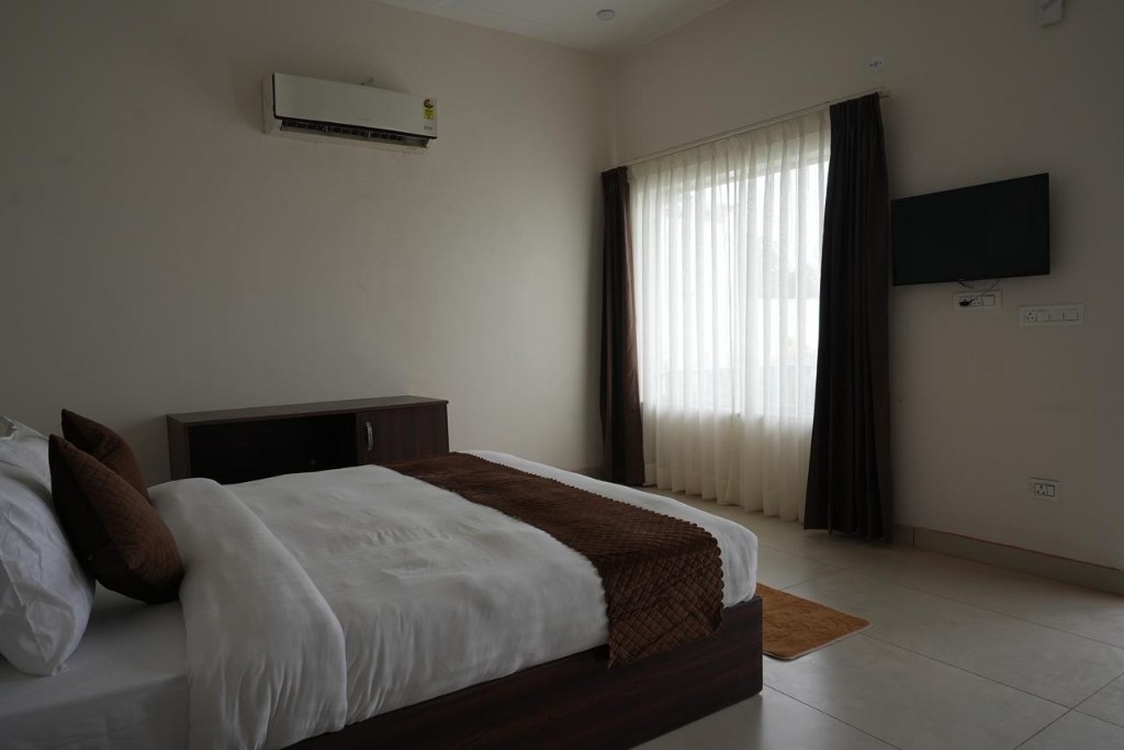 Guest bedroom with wood headboard, white linens, and natural light