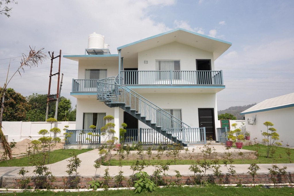 Cottages and two-storey building viewed from covered balcony